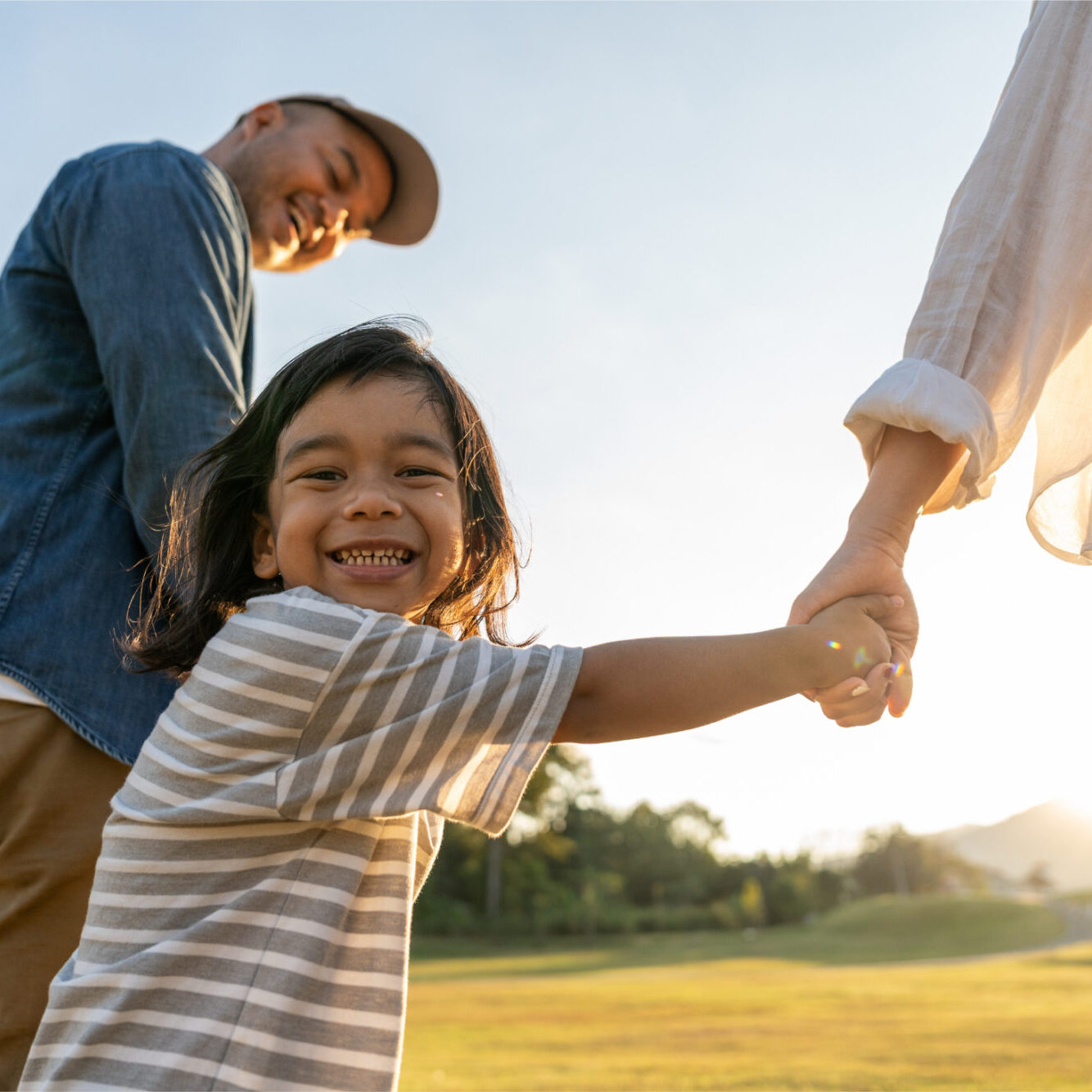 Little girl smiling, breathing well, playing with family outdoors